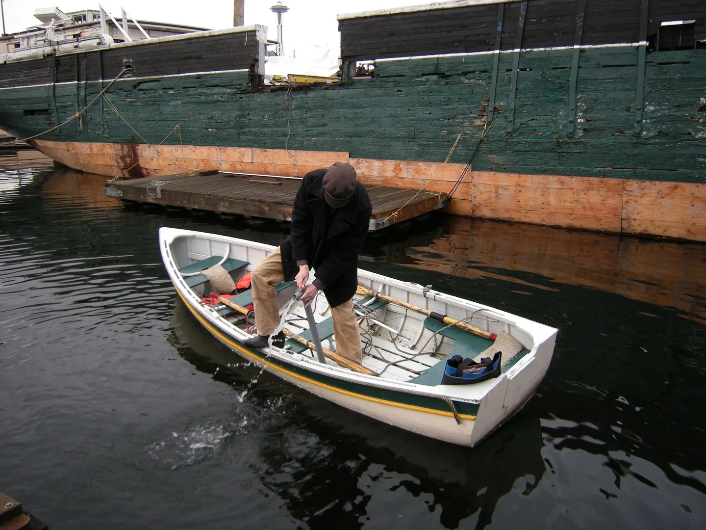 Person bedient eine Hand-Bilgenpumpe auf einem kleinen Holzboot