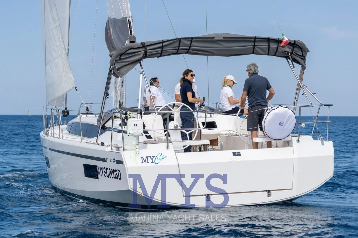 Bavaria C42 von achtern unter Segeln mit Crew im Cockpit