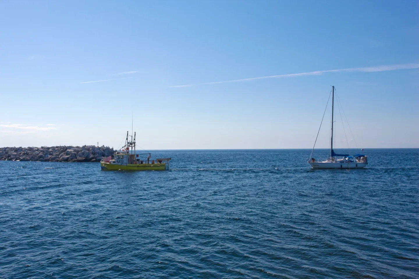 Segelboot wird auf ruhigem Wasser zum Hafen geschleppt