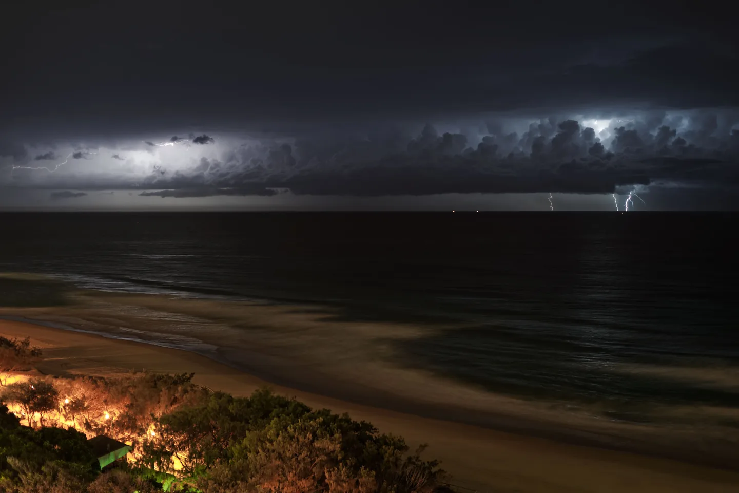 Éclairs ramifiés au-dessus de la mer pendant un orage nocturne