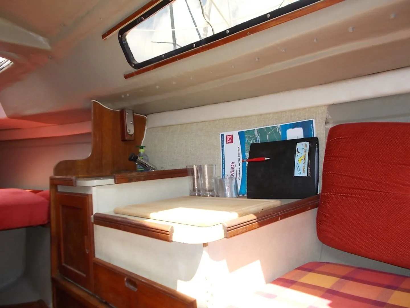 Intérieur réel d’un petit voilier avec coin cuisine et mobilier en bois