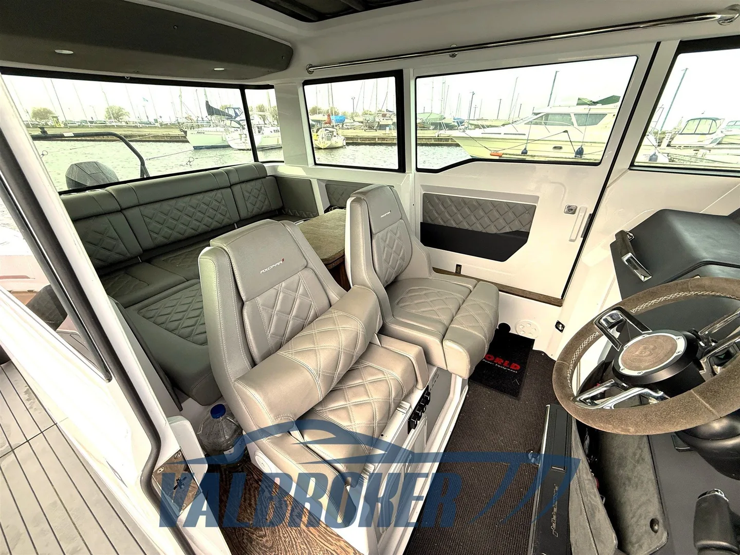 Intérieur de la timonerie Axopar 37 XC avec sièges pilote et banquette